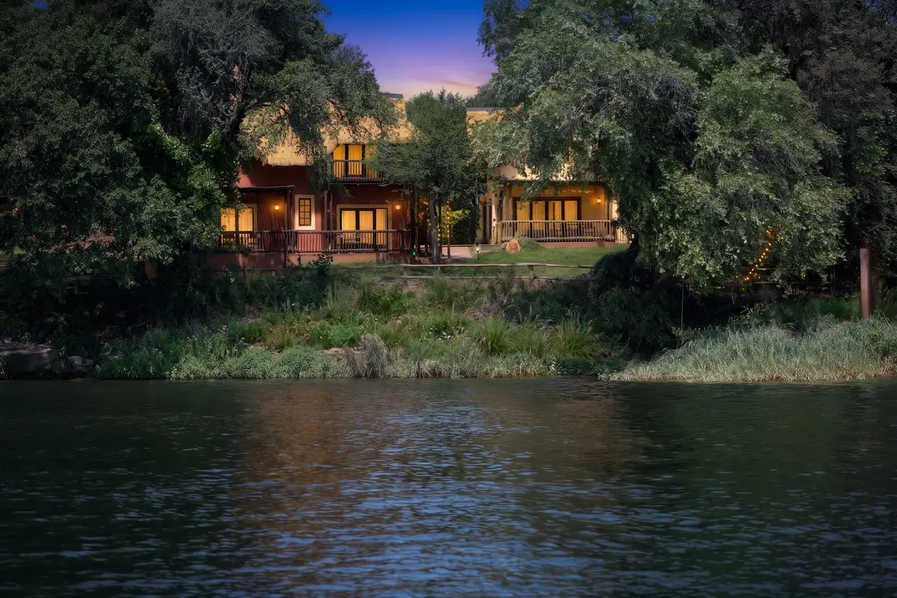 The chalets glowing at dusk, seen from the water
